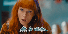 a woman with red hair has the words ah la vache written on her face