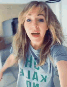 a woman wearing a gray t-shirt with the word ajax on it .