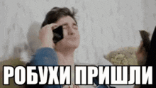 a man is talking on a cell phone while laying on a couch .