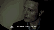 a close up of a man 's face with heavy breathing written on the bottom
