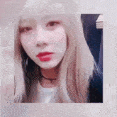 a woman with blonde hair and red lips is wearing a white shirt and a choker necklace .