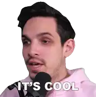 a man wearing a pink hoodie is talking into a microphone and the words it 's cool are visible