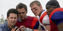 a football player wearing a under armour hat looks at his phone