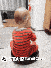 a baby in a red and black striped shirt is sitting on a black object with the words star tamil chat written on the bottom