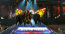 a group of people are walking down a stage with a sign that says all in texas