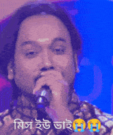 a man singing into a microphone with a tear coming out of his eyes