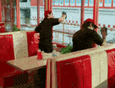 two men cleaning a window in a diner