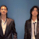 a man and a woman in suits holding hands