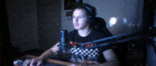a man sitting in front of a microphone wearing a black shirt that says ' matt ' on it