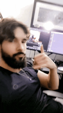 a man with a beard is sitting in front of a computer screen