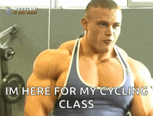 a muscular man says " i 'm here for my cycling class " in a gym