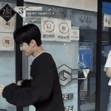 a man stands in front of a sign that says the boyz