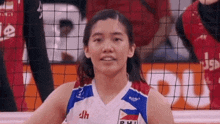 a woman is playing volleyball on a court and smiling .