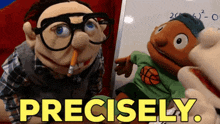 a puppet holding a pencil next to another puppet that says precisely ..