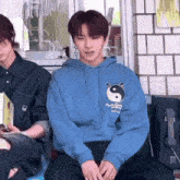 a person wearing a blue hoodie with a yin yang symbol on the front