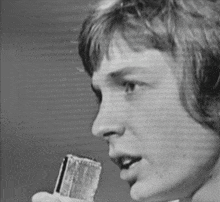 a black and white photo of a man holding a lighter