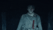 a man with blood on his face is standing in the dark .