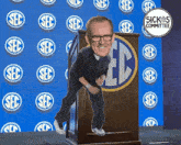 a cartoon of a man standing on a podium with the sec logo behind him