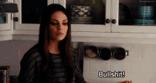 a woman is standing in a kitchen and says bullshit .