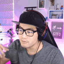 a man wearing glasses and headphones is sitting in front of a sign that says ctfo