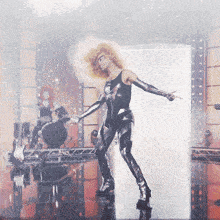 a woman in a black bodysuit is dancing on stage