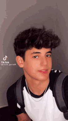 a young man is taking a selfie with a backpack and a tiktok watermark