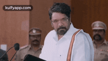 a man with a beard is giving a speech at a podium .