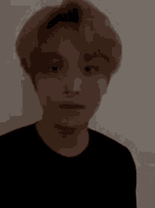 a close up of a person 's face with a black shirt on .