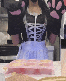 a woman in a maid costume is standing in front of a pink tray of food
