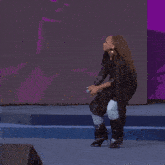a woman singing into a microphone on stage