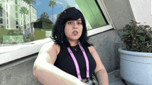 a woman wearing a black tank top with a pink lanyard around her neck that says ' nintendo ' on it