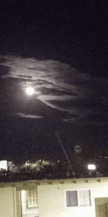 a full moon is visible in the night sky above a motel