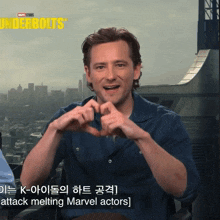 a man making a heart shape with his hands in front of a screen that says underbolts