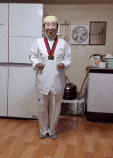 a man with a medal around his neck is standing in a kitchen