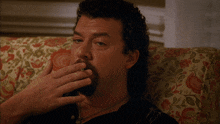 a man with a cigarette in his mouth is sitting in a chair