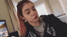 a woman wearing a black jacket that says ny