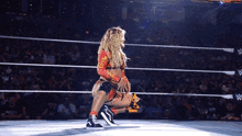 a woman in a wrestling ring with a w logo on the side