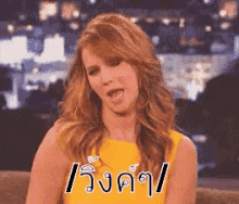 a woman in a yellow dress is sticking her tongue out in a foreign language