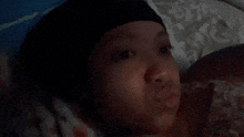 a woman laying on a bed with a black headband on