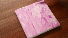 a pink and white piece of paper on a wooden table