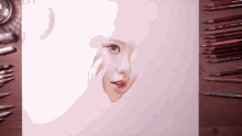 a drawing of a woman 's face is surrounded by colored pencils and markers