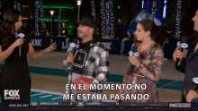 a man holding a football stands in front of a group of fox reporters and says en el momento no me estaba pasando