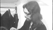 a black and white photo of a man with glasses and long hair