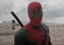 a man in a deadpool costume holding a sword