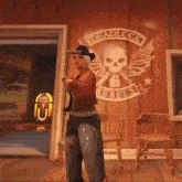 a woman in a cowboy hat is standing in front of a wall with a skull and wings on it .