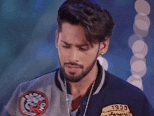 a man with a beard wears a jacket that says rambie on it