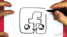 a person is drawing a facebook logo with a pen
