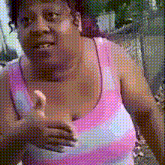 a woman in a pink and blue striped tank top giving a thumbs up