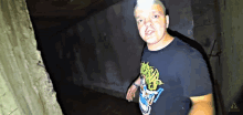 a man wearing a t-shirt that says ' apocalypse ' on it stands in a dark room