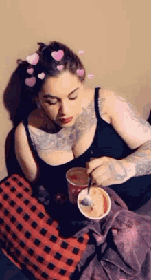 a woman is sitting on a couch eating ice cream with hearts on her hair .
